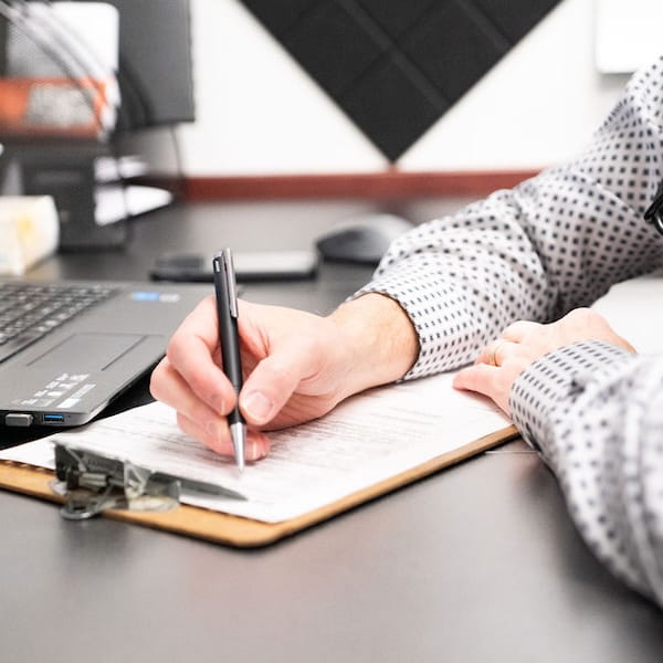Doctor writing on clipboard in medical office